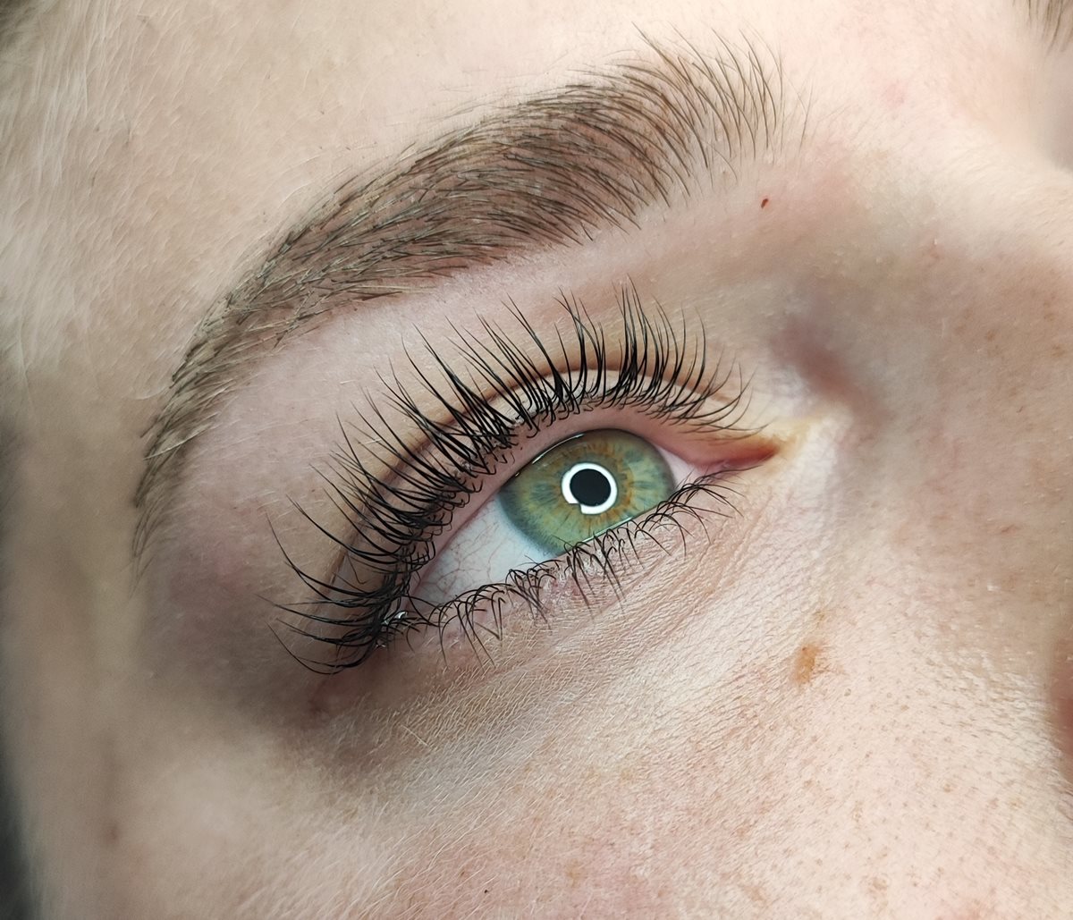 Geliftete Wimpern an einem grünen Auge nach dem Wimpernlifting