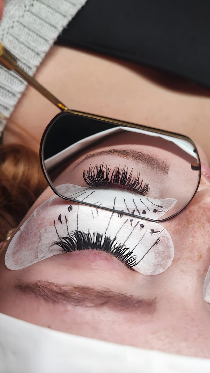 Kontrolle einer frisch gesetzten Wimpernverlängerung im Wet & Wispy Look mit dem Handspiegel